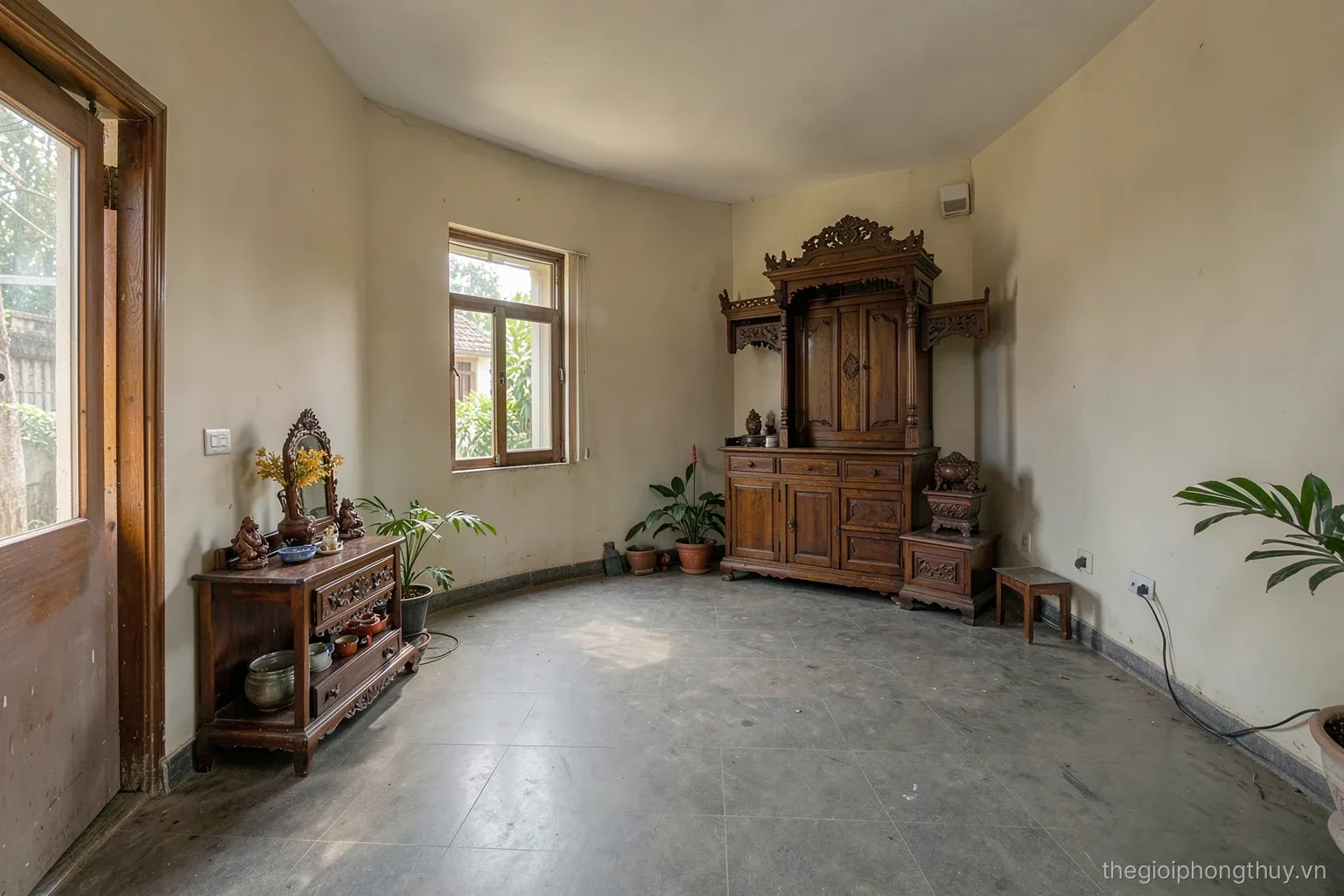Wide view of a Vietnamese shophouse ground floor, a small floor-level altar near the entrance on one side and a tall wooden ancestral altar along the far wall, morning light, no people